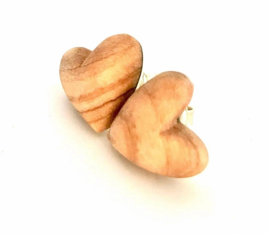 Angled view of handcrafted olive wood heart stud earrings highlighting the depth and curvature
