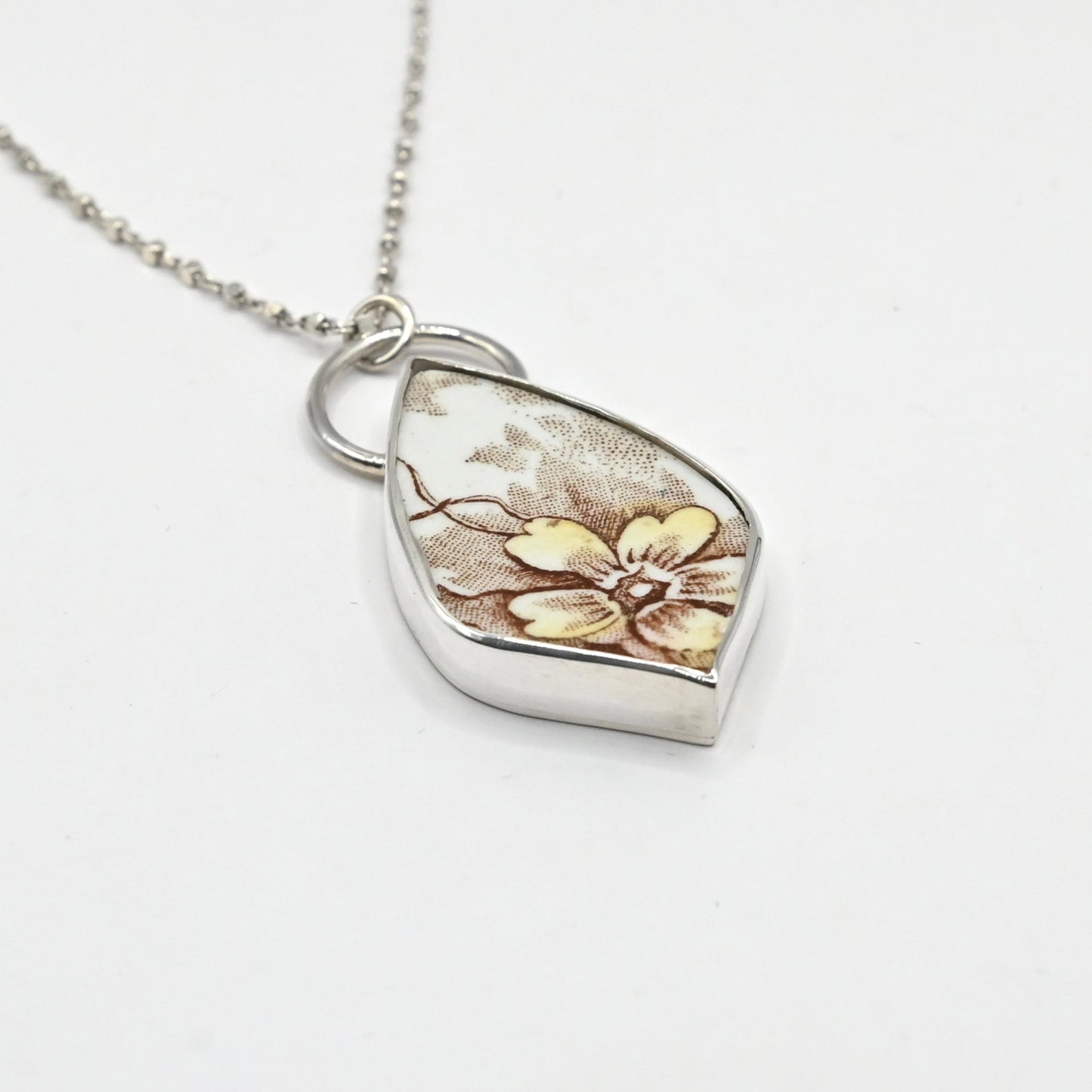 Handcrafted antique ceramic shard pendant in sterling silver - close up detail of floral motif and bezel setting