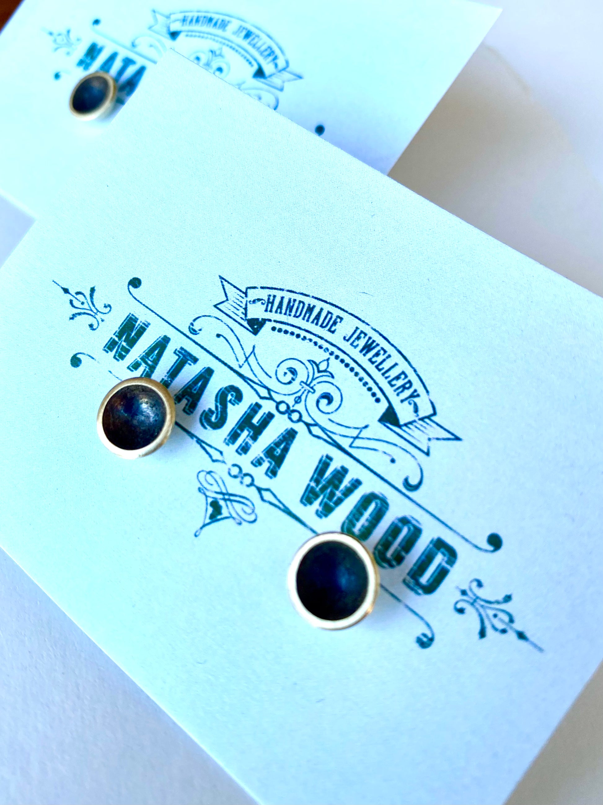 Classic black domed brass stud earrings presented on a custom Natasha Wood Jewellery card