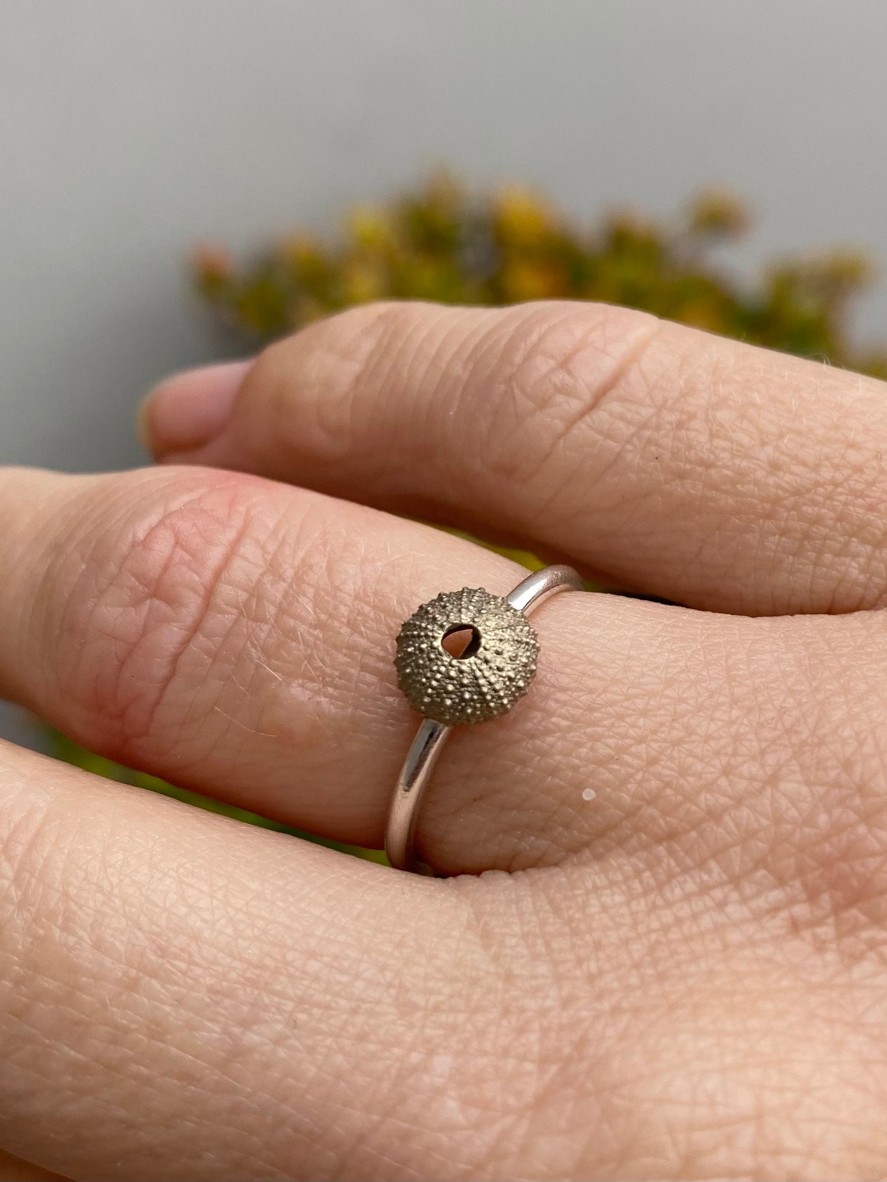 Close-up of a hand wearing a textured sterling silver sea urchin ring