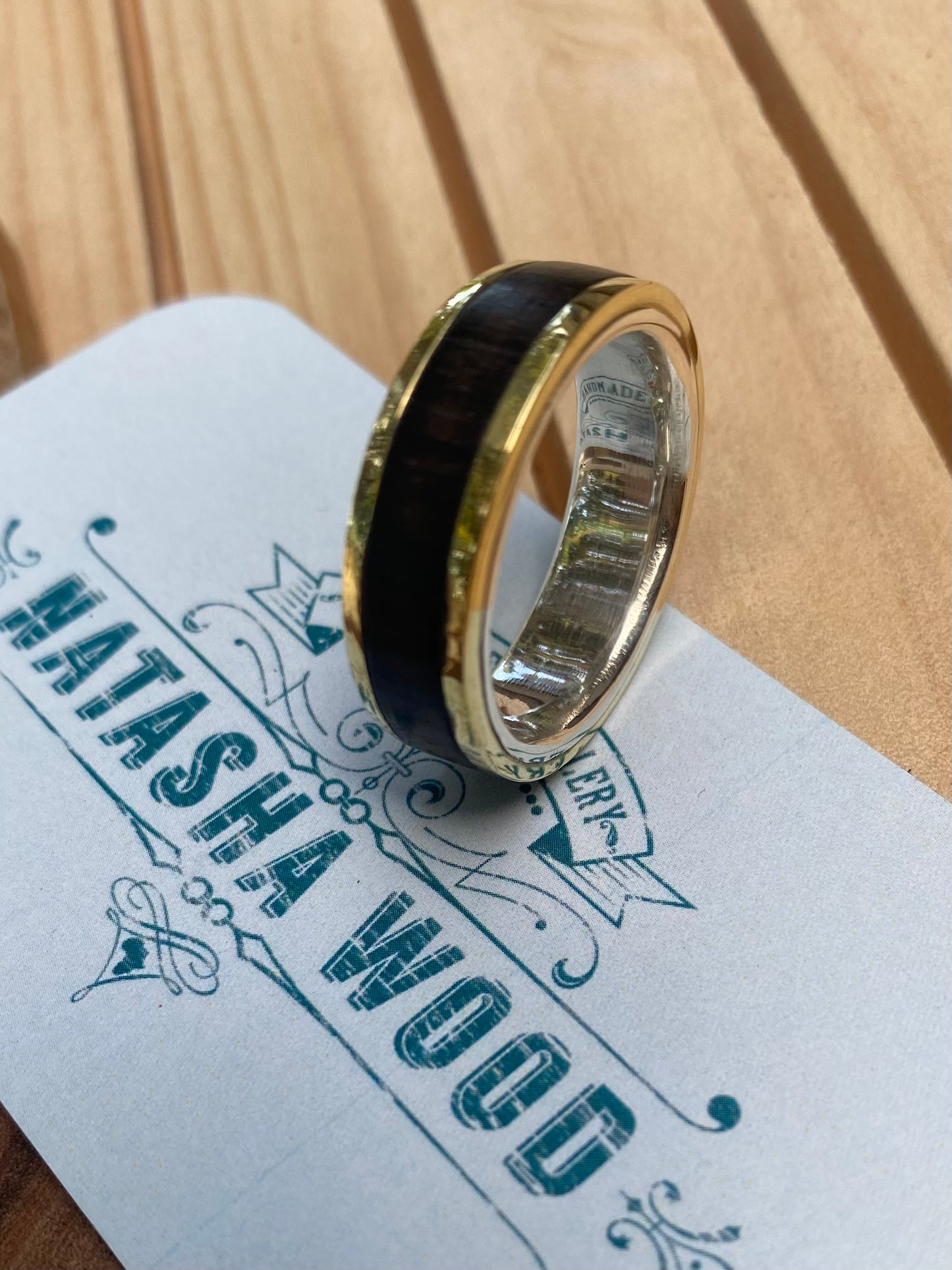 Close-up of the mixed metal and wood ring showcasing the smooth transition between the silver, bronze, and wood materials.