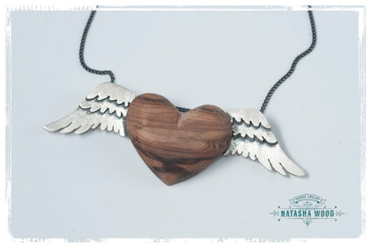 A frontal view of the handcrafted Silver Winged Wooden Heart Pendant, showcasing the intricate design and natural wood texture