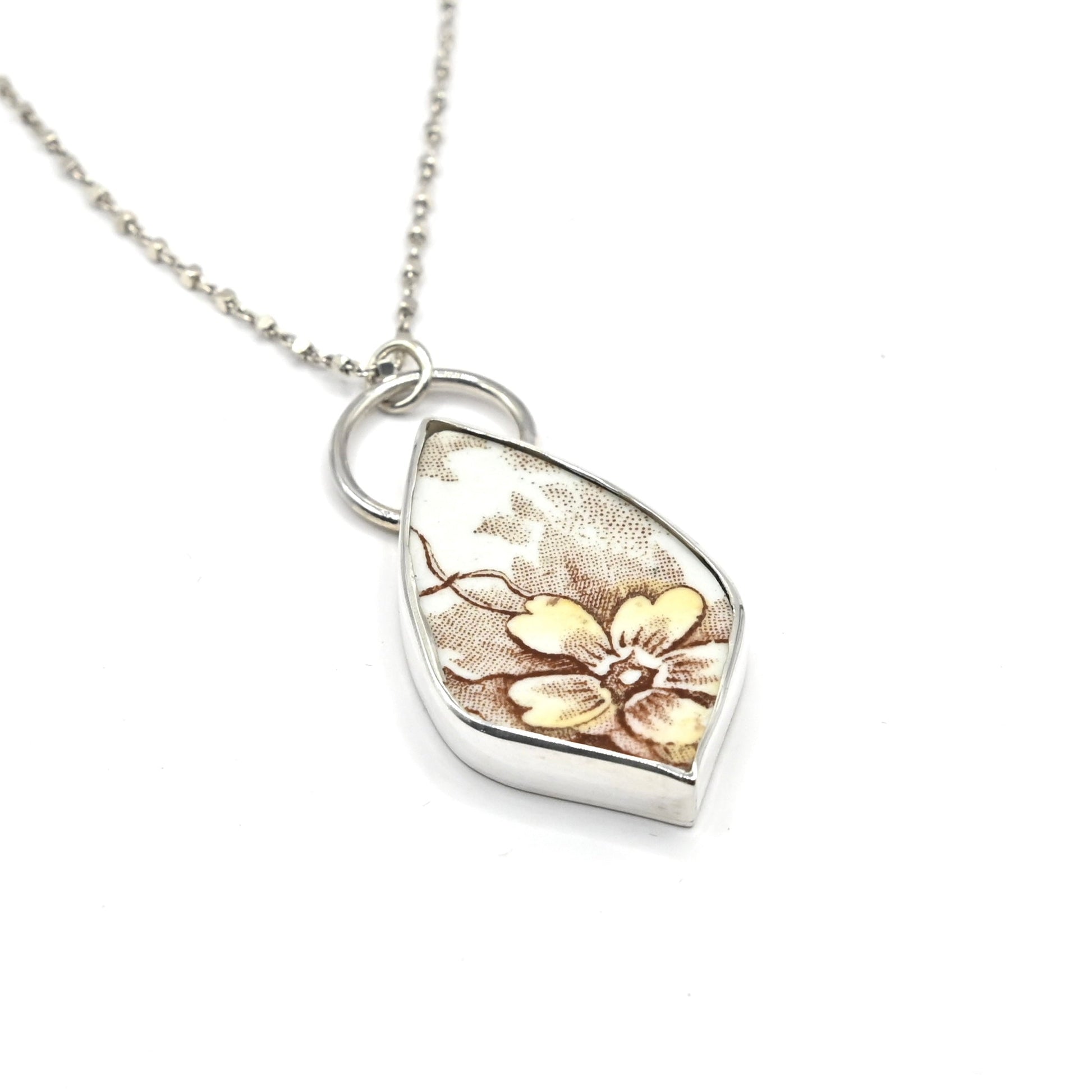 One of a kind antique ceramic floral pendant set in sterling silver bezel - angled view with 42cm trace chain