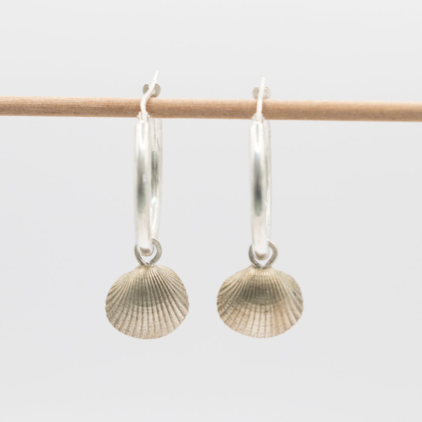 Silver hoops with scallop shell charm