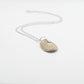 Santa Maria Shell Pendant - side angle flat-lay, brass finish with sterling silver trace chain