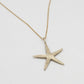 brass Starfish pendant necklace on a light gray background with gold plated chain