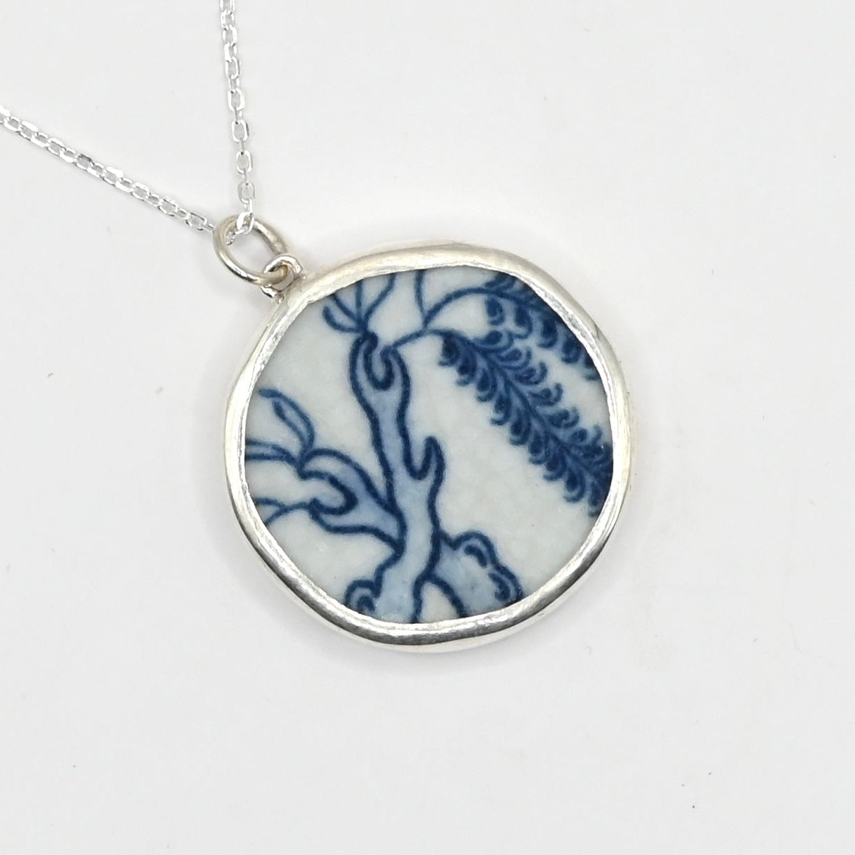 Willow Love Story Pendant - front angled view, antique blue Willow Pattern ceramic set in sterling silver bezel with trace chain
