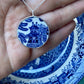 Willow Pattern silver pendant held in hand showing scale - antique blue and white ceramic bezel set in sterling silver