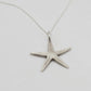 Starfish Pendant Necklace - oxydised sterling silver handcast pendant on thin silver chain, flat-lay