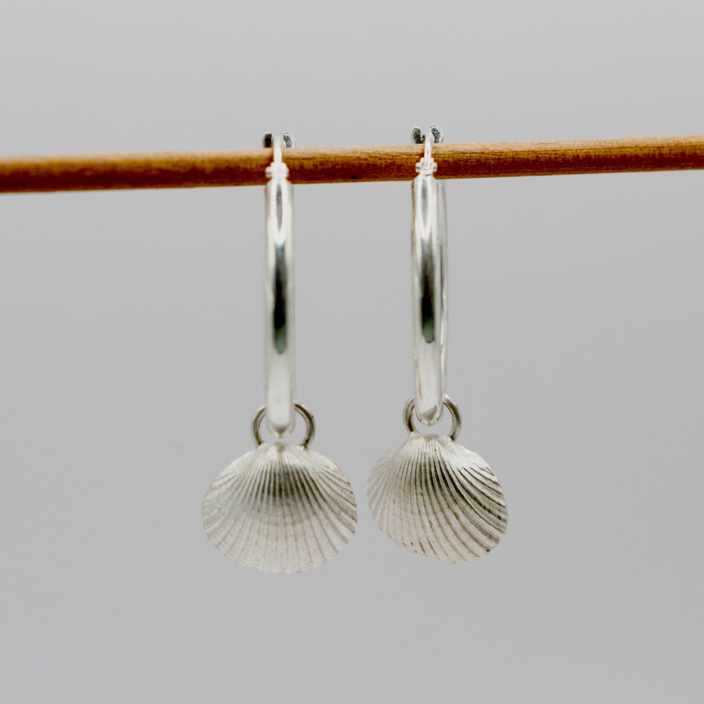 Silver hoops with scallop shell charm