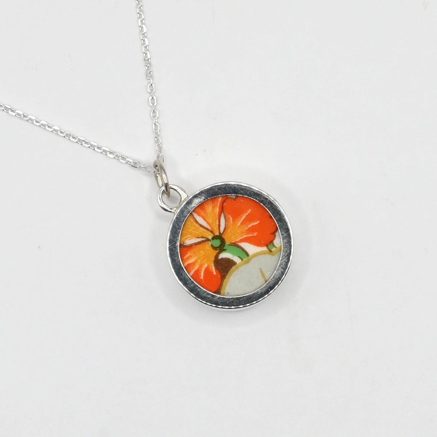 Necklace with a round pendant featuring a colorful design on a white background