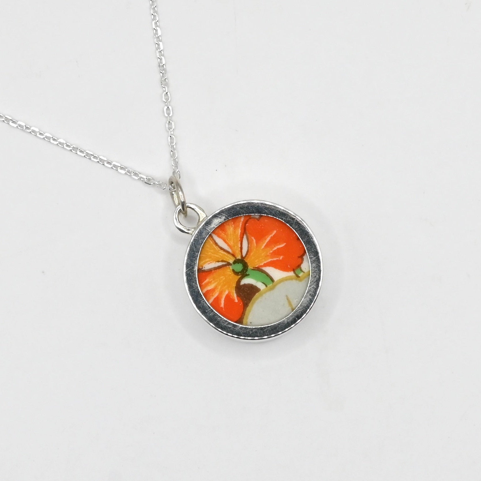 Necklace with a round pendant featuring a colorful design on a white background