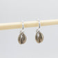 Cowry Shell Hoop Earrings - brass cowry pair hanging on display rod showing drop length