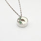 Reversible antique china shard pendant - side angle showing bezel depth and hand-painted floral ceramic face, sterling silver