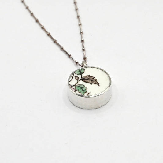 Reversible antique china shard pendant - side angle showing bezel depth and hand-painted floral ceramic face, sterling silver