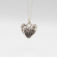 Protea Heart Pendant – sterling silver pendant hanging on grey background showing full chain