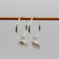 Sterling Silver Scallop Shell Hoop Earrings - pair hanging on display rod, silver charm detail