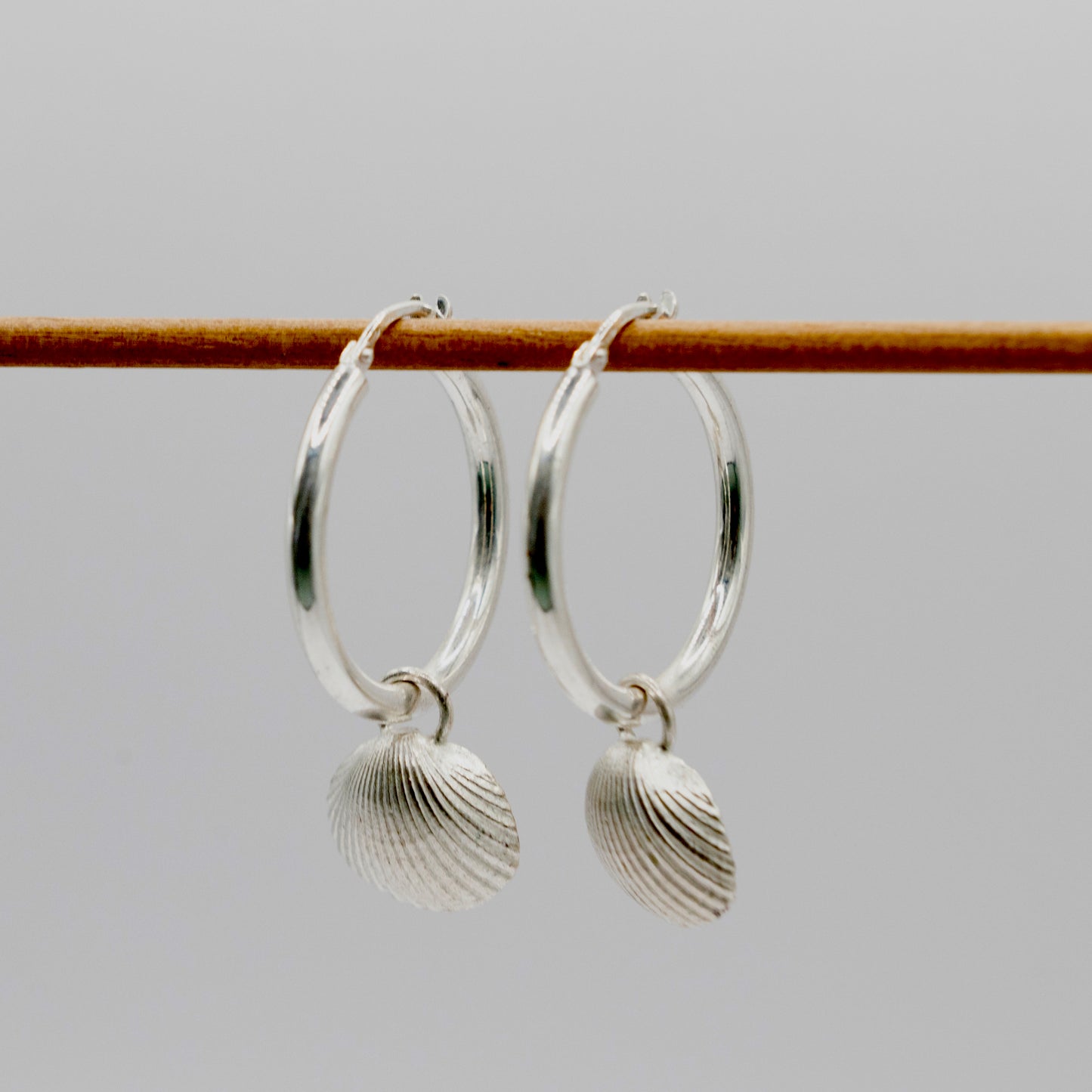 Silver hoops with scallop shell charm