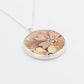 Broken china plate pendant - front face view - pink and yellow floral vintage ceramic set in sterling silver