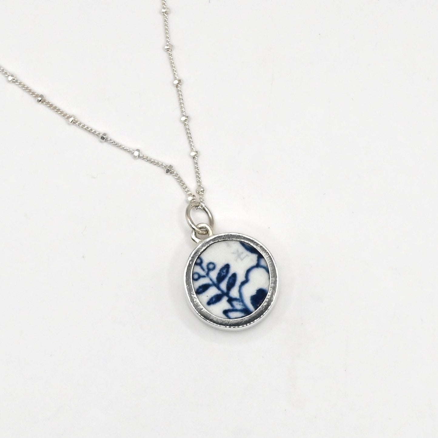 Handcrafted Double Shard Necklace - side angle green floral antique ceramic shard in deep sterling silver cylinder bezel pendant