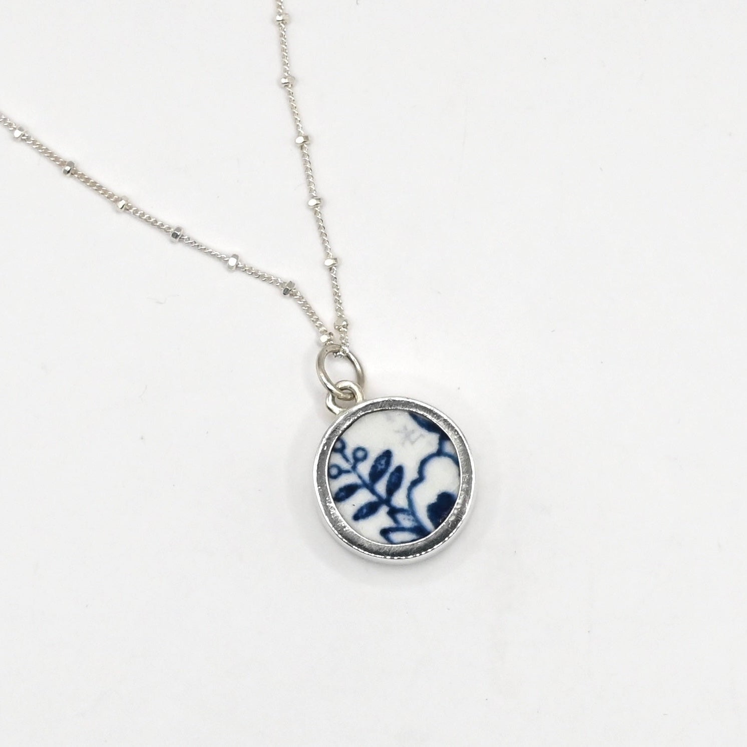 Handcrafted Double Shard Necklace - side angle green floral antique ceramic shard in deep sterling silver cylinder bezel pendant