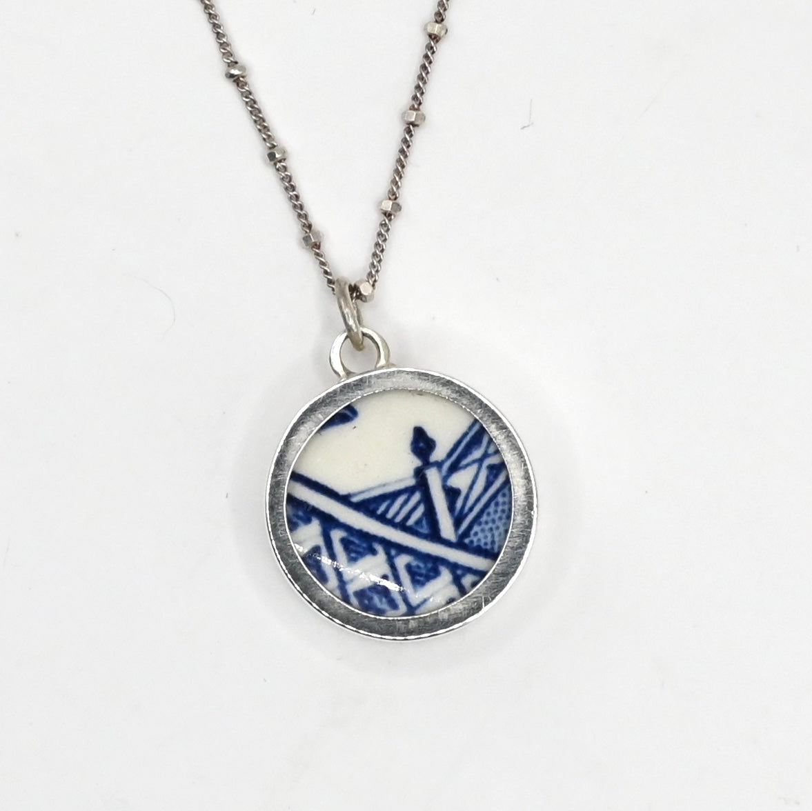 Reversible antique china shard necklace - front face Blue Willow pattern set in sterling silver bezel with satellite chain