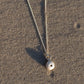 Small Sea Urchin Necklace - sterling silver pendant lying on wet sand, coastal lifestyle