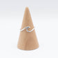 A Sterling Silver Ocean Wave Ring displayed on a wooden cone-shaped stand against a white background.
