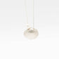 Scallop Shell Pendant Necklace - close flatlay on off-white background showing detailed sterling silver scallop shell ridges, freshwater pearl and chain