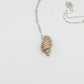 Tulip Conch Necklace - brass variant pendant on sterling silver chain white background side view