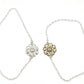 Daisy Flower Bracelet - polished sterling silver daisy charm bracelet on marble surface with yellow flower, detail view