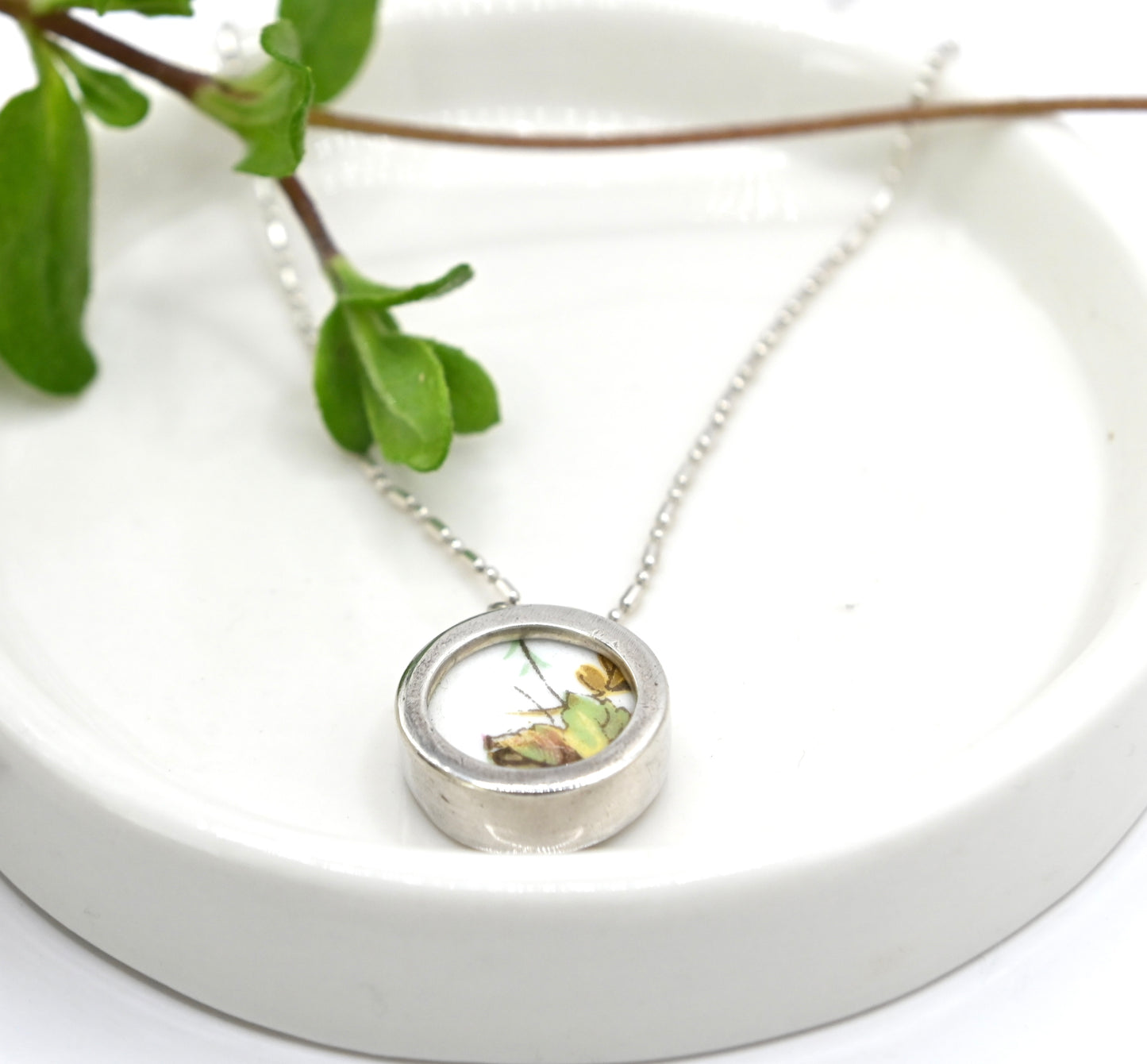 Double sided pendant with broken china