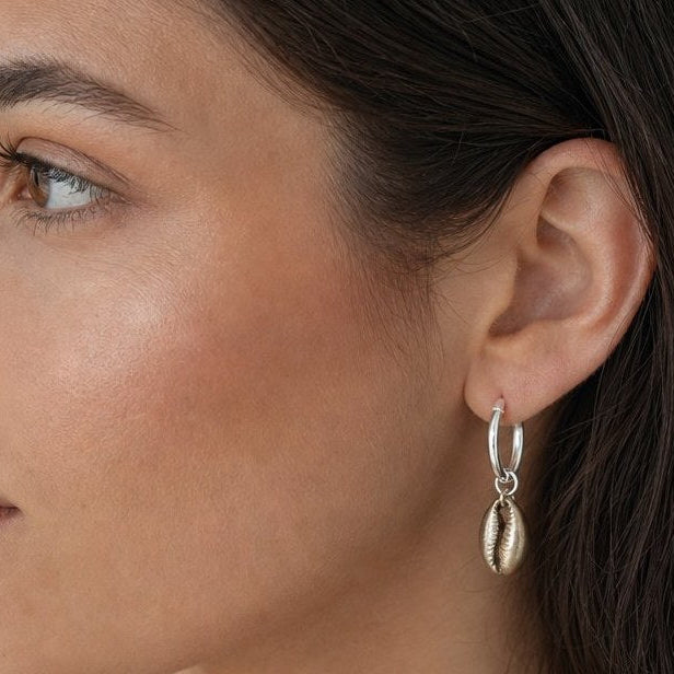 Cowry Shell Hoop Earrings - close-up portrait brass cowry charm detail on silver hoop