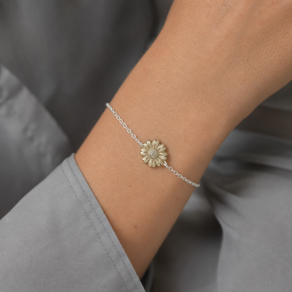 Daisy Flower Bracelet - close-up of brass hand-carved daisy charm detail on sterling silver chain, white background
