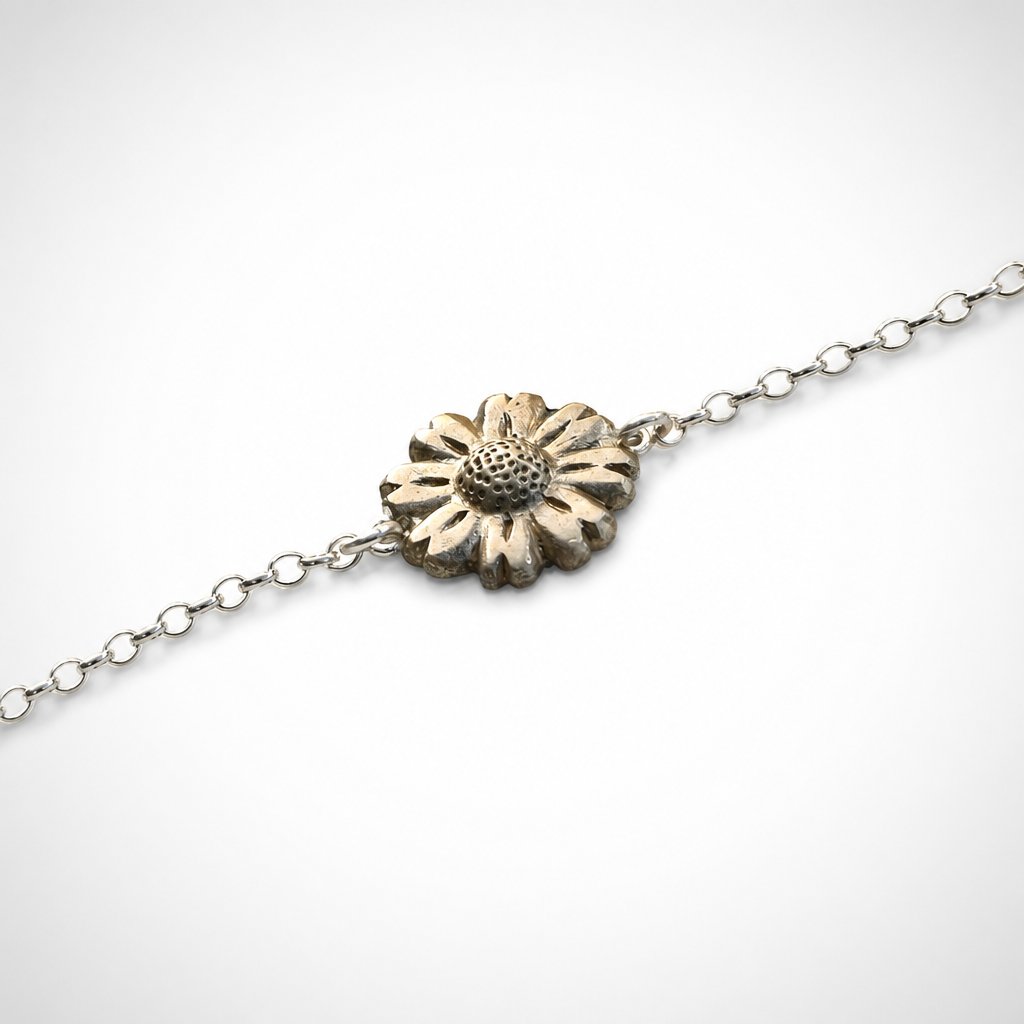 Daisy Flower Bracelet - brass daisy charm on sterling silver chain flat lay showing spring-ring clasp detail, white background