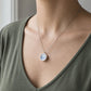 Reversible antique china pendant - angled side view showing double-sided sterling silver bezel depth, Blue Willow ceramic face worn on model