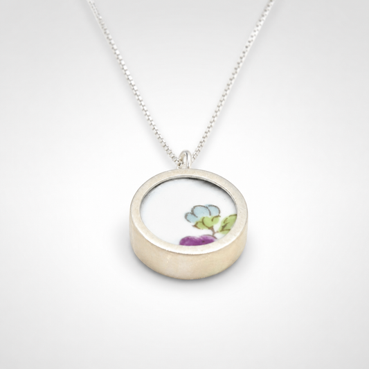 Double-sided broken china pendant - front face floral motif set in sterling silver bezel
