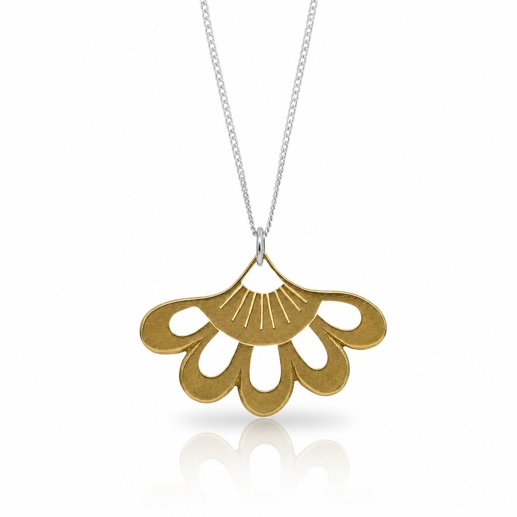 Lotus Flower Pendant - close-up of sterling silver hand-pierced detail on natural wood surface - Natasha Wood Jewellery