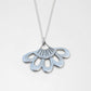 Lotus Flower Pendant - close-up of sterling silver hand-pierced detail on natural wood surface - Natasha Wood Jewellery