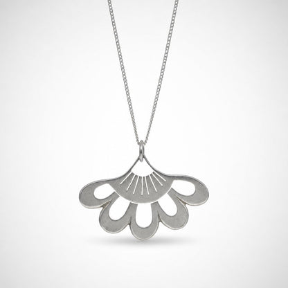 Lotus Flower Pendant - close-up of sterling silver hand-pierced detail on natural wood surface - Natasha Wood Jewellery