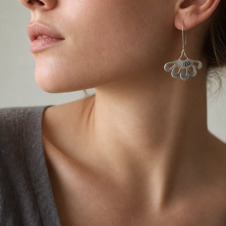 Five-Petal Lotus Hook Earrings - sterling silver pair hanging, showing cut-out petal design and polished finish