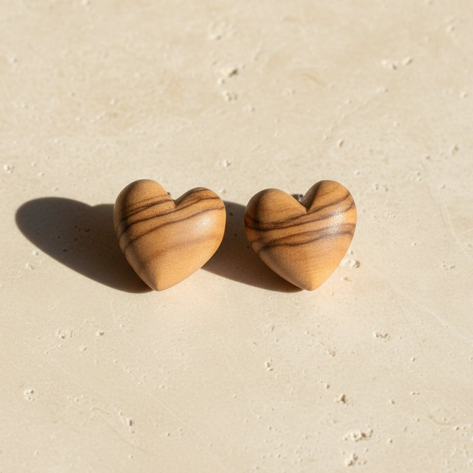 Natasha Wood Jewellery olive wood heart stud earrings - front view, natural grain, sterling silver backs, white background