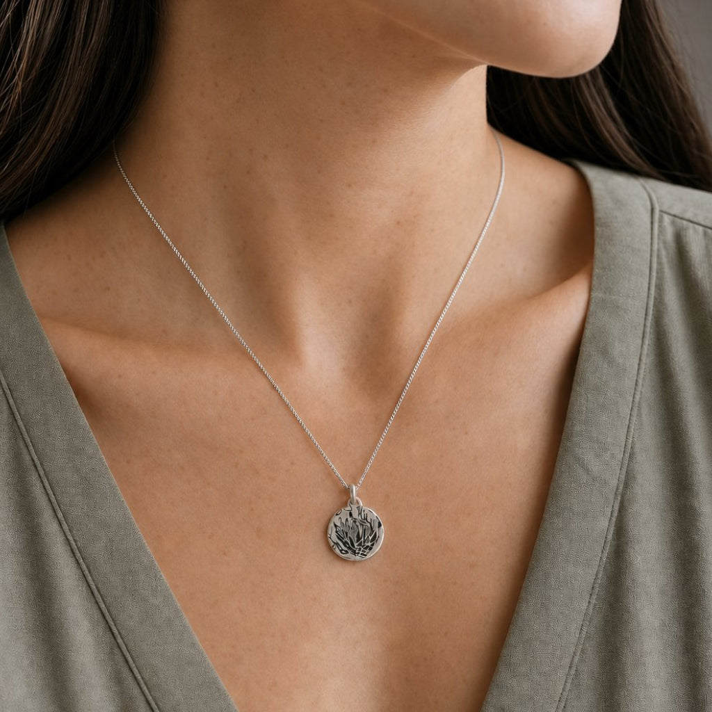 Silver Protea Disc Pendant - angled view showing oxidised Protea imprint on sterling silver disc