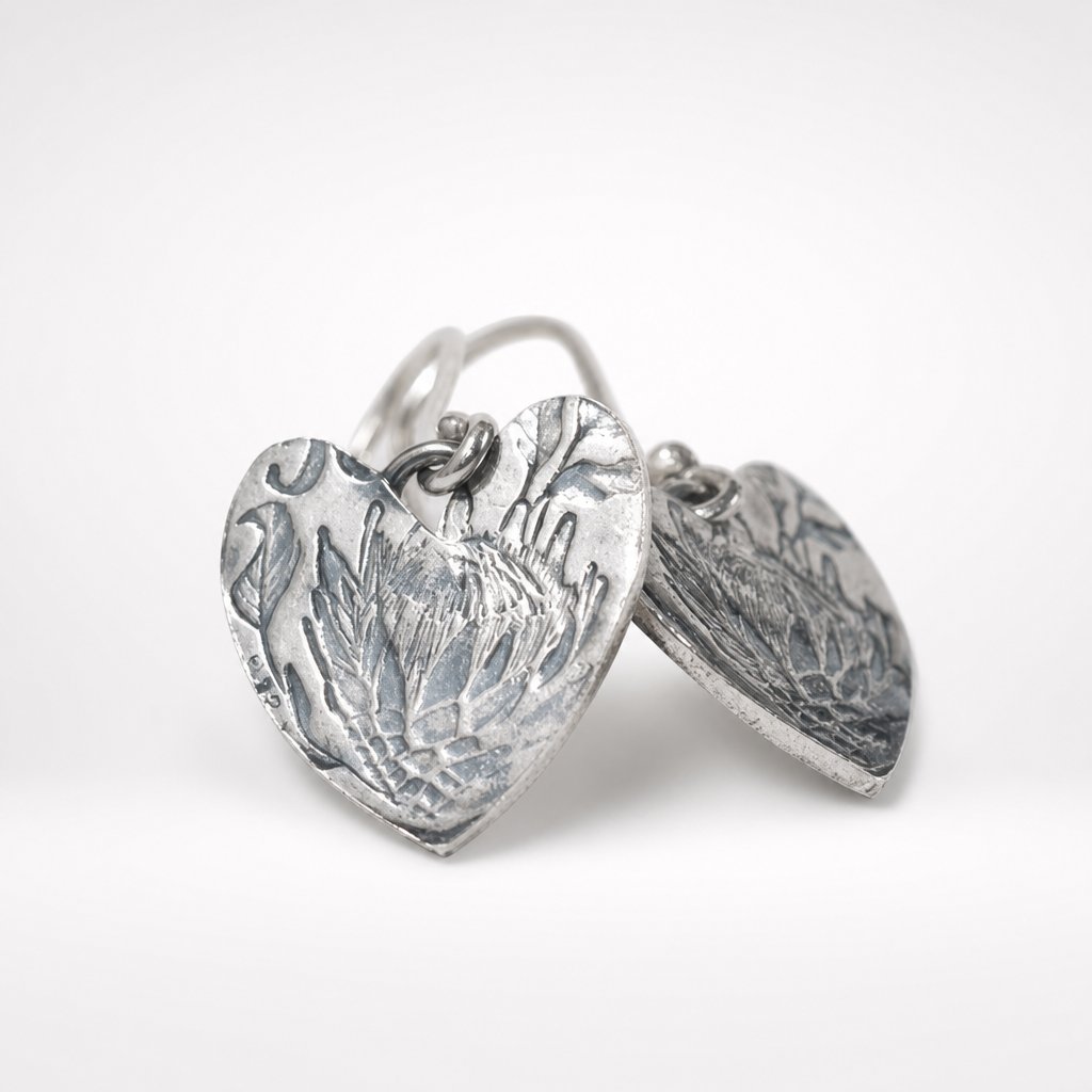 Handcrafted Protea Heart Hook Earrings - flat lay product shot sterling silver etched detail