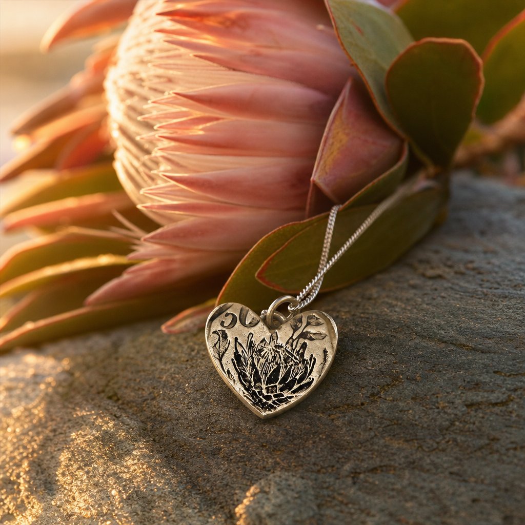 Protea Heart Pendant – brass variant flat-lay on white background – oxidised brass necklace