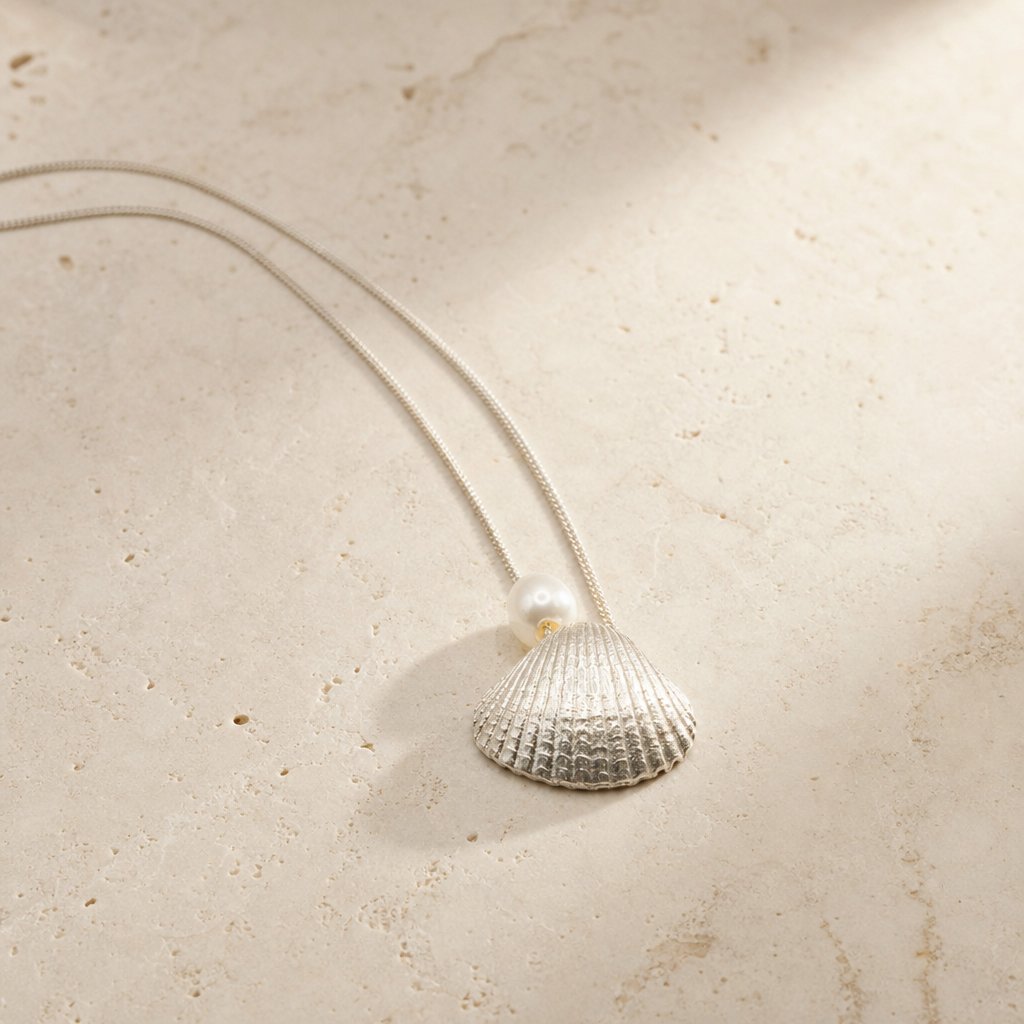 Scallop Shell Pendant Necklace - flatlay angle showing sterling silver shell and freshwater pearl on white background