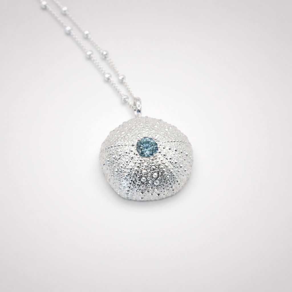 Natasha Wood Jewellery Sterling Silver Sea Urchin Pendant with Blue Topaz on curb chain - overhead flat lay