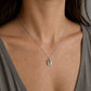 Handmade Sterling Silver Cowrie Shell Pendant Necklace - front hanging view, grey gradient background