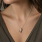 Tulip Conch Necklace - brass variant pendant on sterling silver chain white background side view