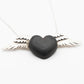 A striking necklace with a heart-shaped pendant carved from rich black wood, adorned with silver wings on either side. The dark wood contrasts sharply with the bright silver, creating a bold and elegant design on a fine silver chain.